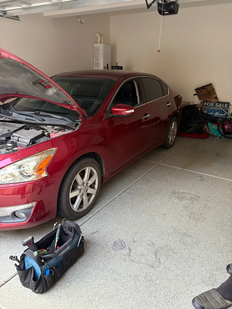 Red Nissan Altima parked inside a home garage during a mobile repair visit - Perris, CA