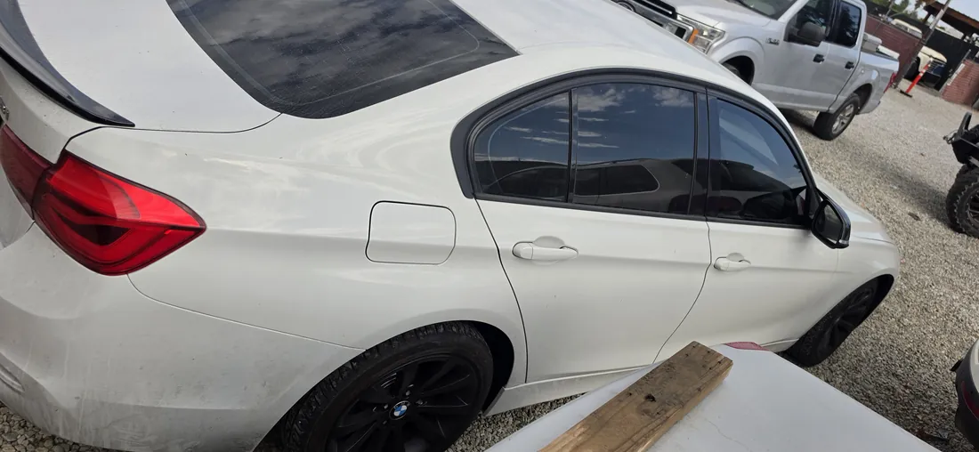 Side view of a white BMW 328i awaiting an engine swap at a repair shop - Temecula, CA