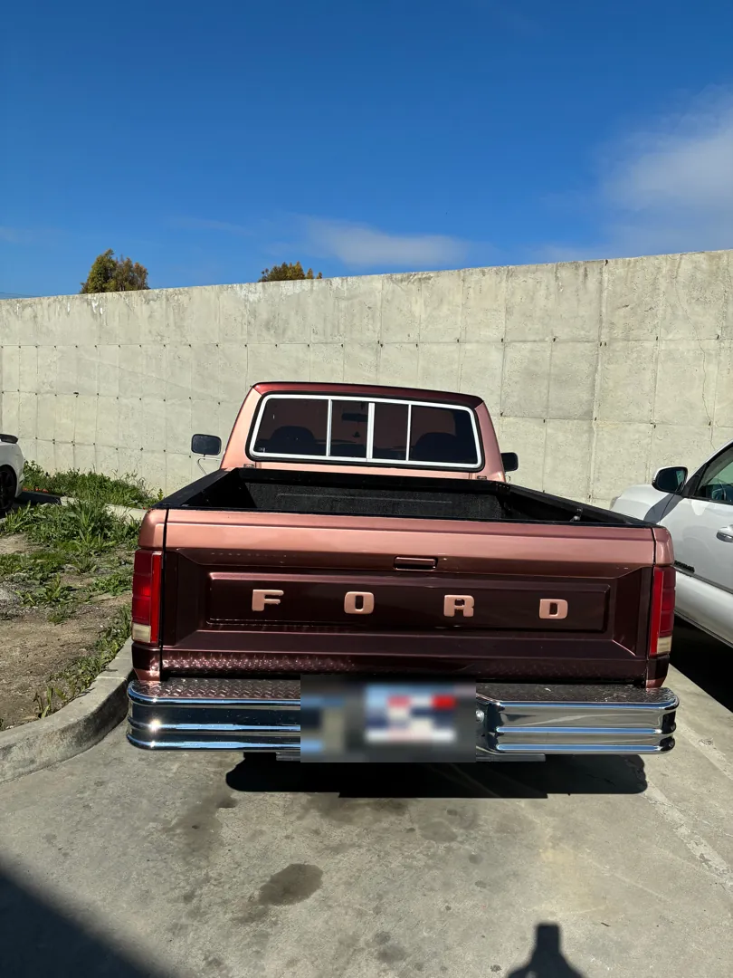 Rear view of an 80s Ford F-Series pickup parked against a concrete wall before an engine swap - Lake Elsinore, CA