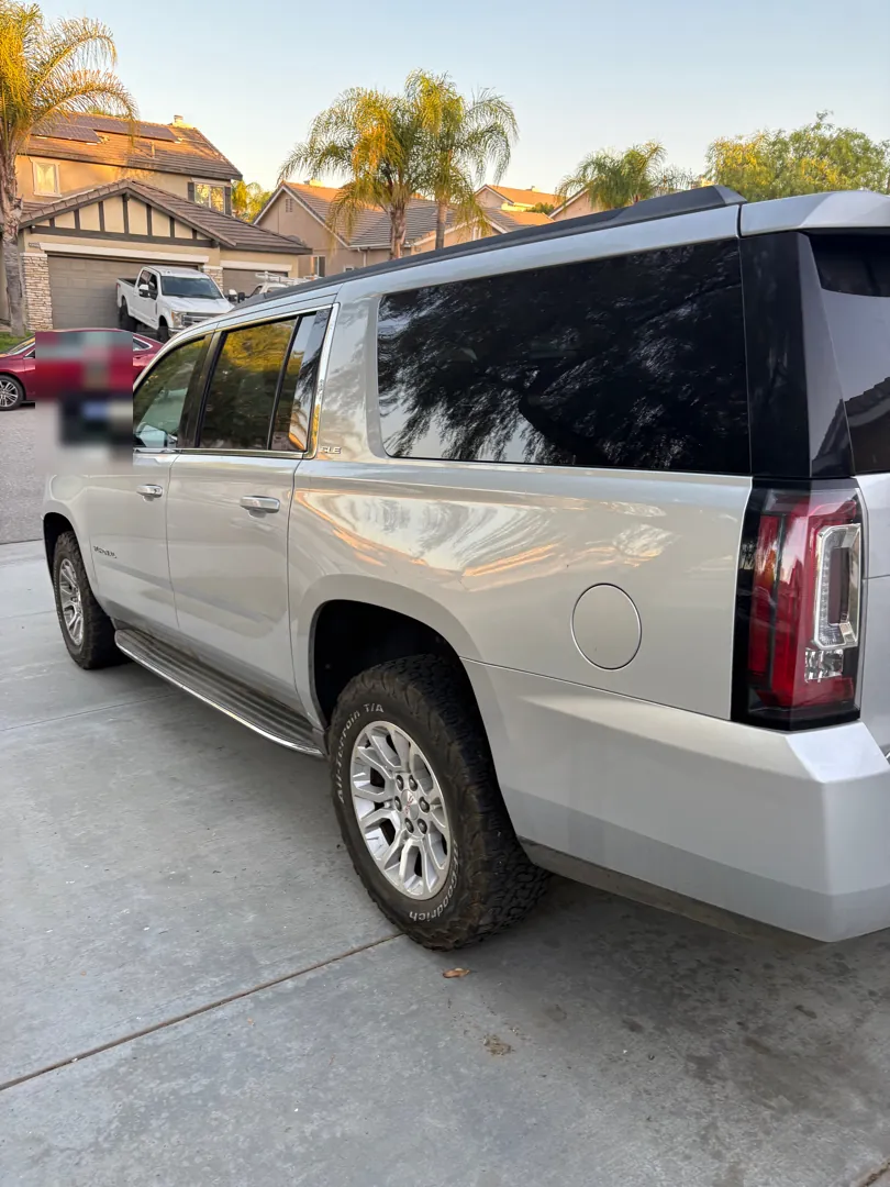 Silver GMC Yukon XL parked side on in a suburban driveway at dusk during a mobile diagnostic - Menifee, CA