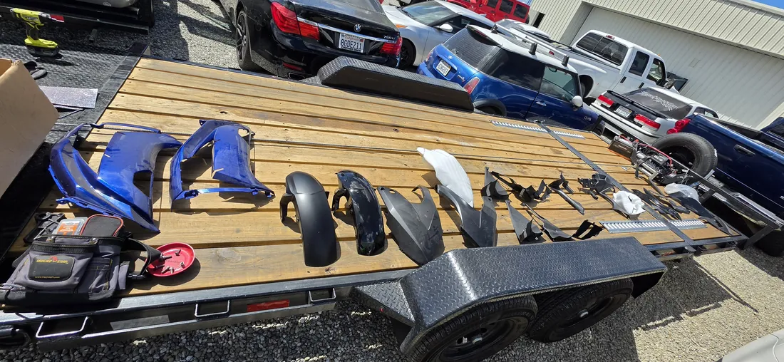Motorcycle fairing panels laid out in order on a trailer deck during a rebuild - Murrieta, CA